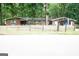 Street view of single-story brick home with mature trees and rustic fence at 3010 Waters Rd Sw, Atlanta, GA 30354