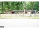 Single-story brick home with lush, mature trees and rustic wooden fence at 3010 Waters Rd Sw, Atlanta, GA 30354