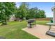 A peaceful backyard featuring a patio with a grill, spacious lawn, and privacy fence at 140 Canyons, Hampton, GA 30228