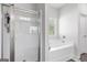 Bathroom with glass enclosed shower and soaking tub with a window at 140 Canyons, Hampton, GA 30228