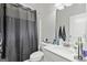 A well-lit bathroom with a sleek vanity, toilet, and a stylish shower curtain at 140 Canyons, Hampton, GA 30228