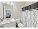 A bright bathroom featuring a modern sink and vanity, toilet, and patterned shower curtain at 140 Canyons, Hampton, GA 30228