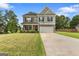 Charming two-story home featuring stone accents, a well-manicured lawn, and a spacious two-car garage at 140 Canyons, Hampton, GA 30228