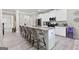 Spacious kitchen featuring a large island with seating, stainless steel appliances and bright white cabinets at 140 Canyons, Hampton, GA 30228