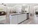 Kitchen island with granite countertop, seating, and view of the open-concept living space at 140 Canyons, Hampton, GA 30228