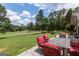 Inviting backyard patio with an outdoor dining set overlooking the lush golf course and tree-lined landscape at 410 Golf View Dr, Peachtree City, GA 30269