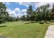 Expansive backyard view showcasing a meticulously maintained lawn with mature trees, overlooking a scenic golf course at 410 Golf View Dr, Peachtree City, GA 30269