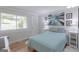 Light and airy bedroom with wood floors, neutral walls, and a large window with a view of the yard at 410 Golf View Dr, Peachtree City, GA 30269