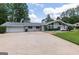 Charming one-story home features a stone chimney, large driveway and manicured lawn at 410 Golf View Dr, Peachtree City, GA 30269