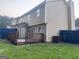A view of the back of the house with deck, fenced yard, and grassy area at 990 Hickory Bend Rd, Atlanta, GA 30349