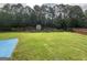 A well-maintained lawn in the backyard, enclosed by a wooden fence and trees, provides a peaceful retreat at 1141 Norsworthy Ml, Hampton, GA 30228
