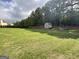Lush green backyard with a storage shed and privacy fence, offering ample space for outdoor activities at 1141 Norsworthy Ml, Hampton, GA 30228