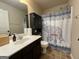 Functional bathroom featuring a vanity, toilet, and shower with decorative curtain, creating a practical and stylish space at 1141 Norsworthy Ml, Hampton, GA 30228