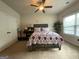 Bedroom featuring a ceiling fan, double closet, and a large window for natural light at 1141 Norsworthy Ml, Hampton, GA 30228