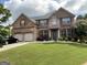 Inviting two-story brick home with lush lawn, landscaped yard, and two-car garage at 1141 Norsworthy Ml, Hampton, GA 30228