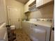 Practical laundry room with washer, dryer, storage cabinets, and convenient access to the outside, enhancing functionality at 1141 Norsworthy Ml, Hampton, GA 30228
