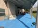 Covered patio area with an adjacent building and blue concrete flooring, perfect for outdoor relaxation and entertainment at 1141 Norsworthy Ml, Hampton, GA 30228
