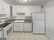 Well-lit kitchen featuring white cabinetry, appliances, and tile floors at 1480 D Ne Pine Log Rd # D, Conyers, GA 30012
