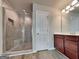 Bathroom features a glass-enclosed shower, wood-style flooring, and a wooden vanity with chrome fixtures at 3712 Upland Dr, Mcdonough, GA 30253