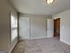 Bedroom featuring neutral walls and carpet with a window, and two white paneled doors at 3712 Upland Dr, Mcdonough, GA 30253