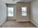 Bright bedroom with neutral walls and carpet and natural light from the two windows at 3712 Upland Dr, Mcdonough, GA 30253