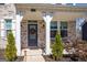 Charming front porch features brick accents, white columns, and a welcoming entrance with decorative plants at 8110 Brewton Bnd, Cumming, GA 30028