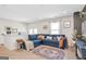 Bright living room featuring a blue sofa and a patterned rug at 8110 Brewton Bnd, Cumming, GA 30028