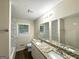 Bathroom with a double sink granite vanity and marble-tiled shower and bath at 3403 Linda Dr, Lithia Springs, GA 30122