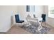 Cozy home office with a sleek white desk, blue chairs, and a decorative rug, perfect for productivity at 2339 Argento Cir, Dacula, GA 30019