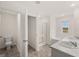 Bright bathroom featuring double vanity, a walk-in closet, a bathtub, and a window at 1628 Palladian Dr, Lithonia, GA 30058