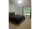Comfortable bedroom featuring plush carpet, neutral walls, and a large window at 3775 Highway 16 E, Sharpsburg, GA 30277