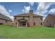 Expansive brick home featuring a covered patio with outdoor seating in a well-maintained backyard at 312 Relative Trl, Mcdonough, GA 30253