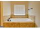 Bathroom featuring a large soaking tub beneath a window with blinds at 312 Relative Trl, Mcdonough, GA 30253