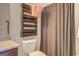 View of a toilet next to a shower with a decorative wooden towel rack at 312 Relative Trl, Mcdonough, GA 30253