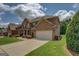 Elegant brick home exterior with a spacious driveway, lush lawn, and well-manicured landscaping at 312 Relative Trl, Mcdonough, GA 30253