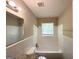 Clean bathroom with white tiled walls and shower-over-tub, and granite vanity at 2015 Boulderview Se Dr, Atlanta, GA 30316