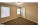 Inviting bedroom featuring new carpeting, two windows providing natural light, and neutral wall paint at 2015 Boulderview Se Dr, Atlanta, GA 30316