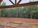 View of the backyard from under the covered porch, revealing a wooded landscape at 365 Spruill Bridge Road # 7 - Helmsley Park, Temple, GA 30179
