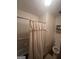 Cozy bathroom featuring a tub with shower, floral wallpaper, and neutral-toned fixtures at 8440 Winston Way, Jonesboro, GA 30236