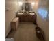 Bathroom with dual sink vanity with wood cabinets, wallpapered walls and window at 8440 Winston Way, Jonesboro, GA 30236