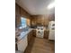 The kitchen features wood cabinetry, stainless steel sink and white appliances at 8440 Winston Way, Jonesboro, GA 30236