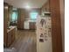 The kitchen features wood cabinetry, white appliances, wood-look floors and eat-in kitchen at 8440 Winston Way, Jonesboro, GA 30236