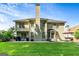 Expansive back exterior features a tall chimney, a well-manicured lawn, and a patio with grill at 1605 Cascade Overlook, Peachtree City, GA 30269