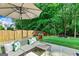 Stylish patio seating arrangement with an umbrella and lush greenery surrounding the backyard at 1605 Cascade Overlook, Peachtree City, GA 30269
