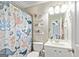 Bright bathroom featuring a shower/tub combo with a decorative shower curtain, floating shelves, and a modern vanity at 1605 Cascade Overlook, Peachtree City, GA 30269