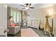 Bedroom featuring a crib, rocker, changing table, giraffe decor and natural light, creating a warm and inviting space at 1605 Cascade Overlook, Peachtree City, GA 30269