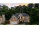 Beautiful brick home featuring a well-maintained lawn, mature trees, and a two-car garage at 1605 Cascade Overlook, Peachtree City, GA 30269