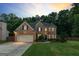 Charming brick home with a well-manicured lawn, lush trees, and an attached two-car garage at 1605 Cascade Overlook, Peachtree City, GA 30269