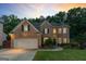 Lovely brick home with manicured lawn, mature trees, and ample parking at sunset at 1605 Cascade Overlook, Peachtree City, GA 30269