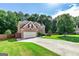 A spacious home with a long driveway and lush green lawn surrounded by mature trees at 1605 Cascade Overlook, Peachtree City, GA 30269
